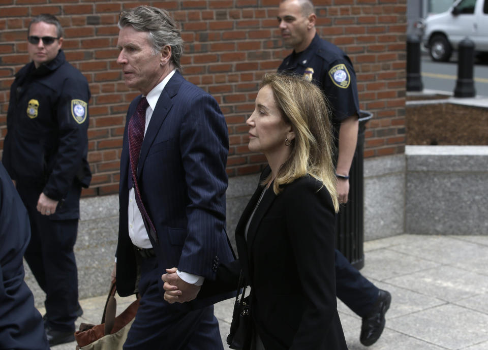 Felicity Huffman arrives with her brother Moore Huffman Jr., at federal court Monday, May 13, 2019, in Boston, where she is scheduled to plead guilty to charges in a nationwide college admissions bribery scandal. (AP Photo/Steven Senne)