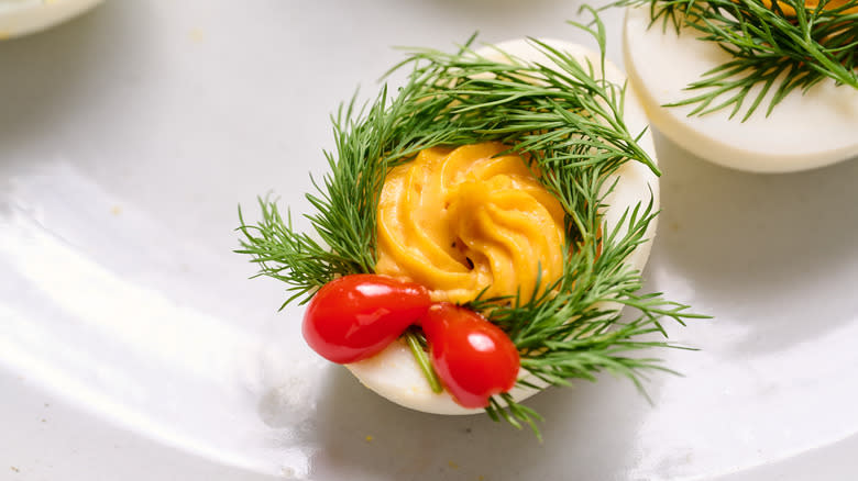 deviled egg with dill wreaths and pepper bow, close up