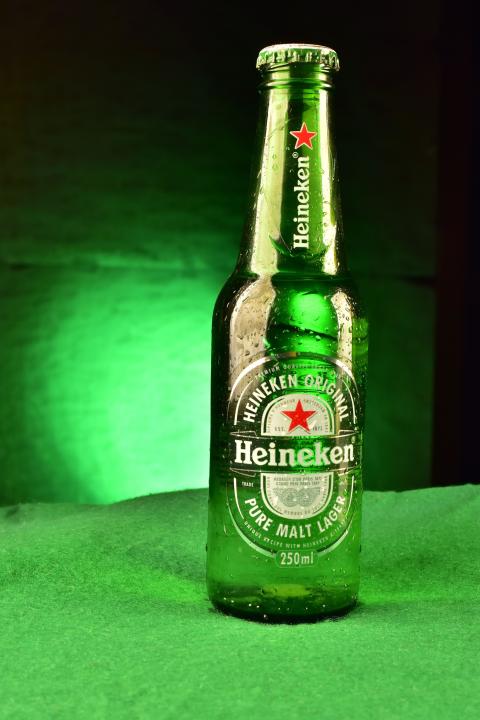 Bottle of Heineken beer on green background