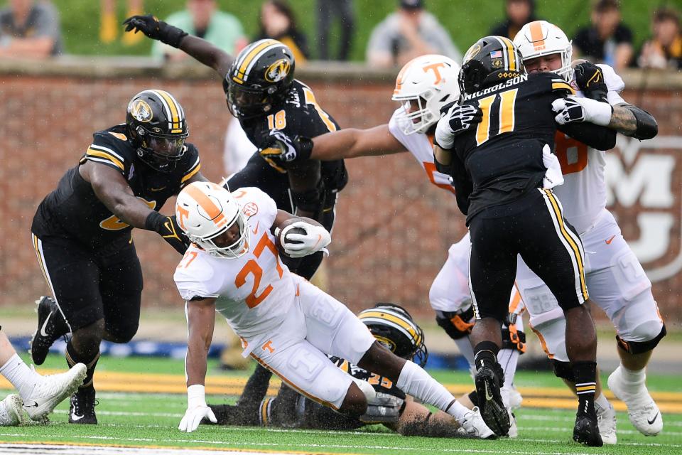 Tennessee running back Len'Neth Whitehead (27) is tripped up by Missouri linebacker Blaze Alldredge (25), Missouri defensive lineman Trajan Jeffcoat (18) and Missouri defensive lineman Akial Byers (0) during a game Oct. 2 at Faurot Field.