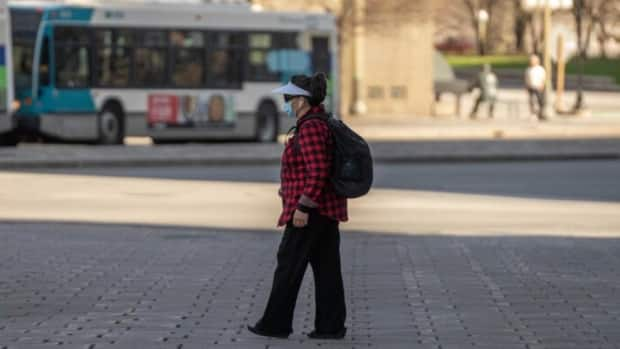 A masked pedestrian walks near the National War Memorial in Ottawa April 8, 2021.