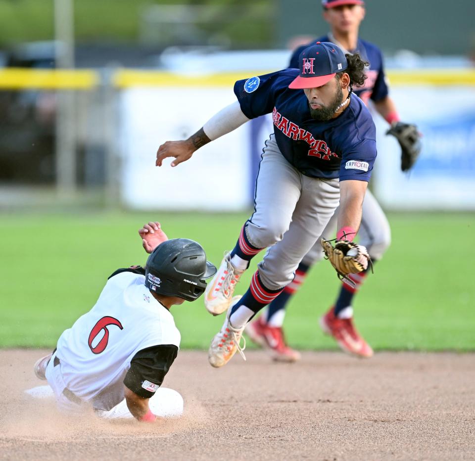 In this July 31 photo, Jo Oyama of Orleans slides safely into second ahead of the tag by Harwich second baseman Danniel Rivera in Cape League action.