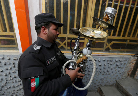 A policeman confiscates shisha water pipes from a shisha cafe during a raid in Kabul, Afghanistan November 27, 2016. REUTERS/Mohammad Ismail