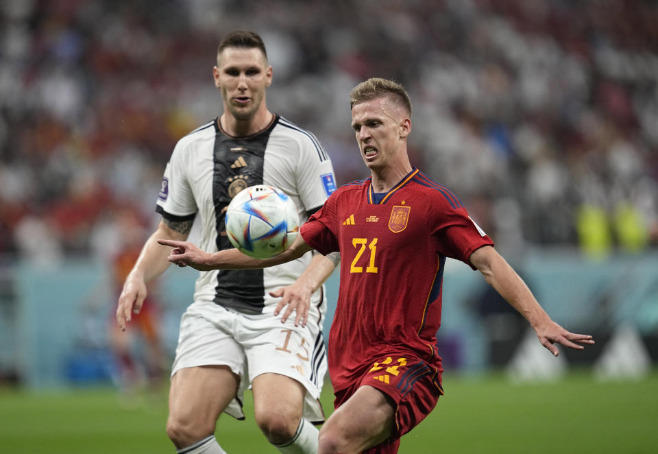 Spain's Dani Olmo controls the ball, followed by Germany's Niklas Suele during the World Cup group E soccer match between Spain and Germany, at the Al Bayt Stadium in Al Khor, Qatar, Sunday, Nov. 27, 2022. (AP Photo/Ebrahim Noroozi)