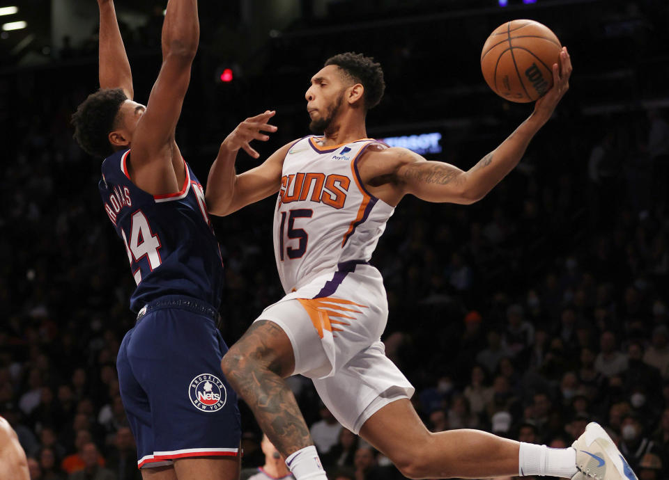 NEW YORK, NEW YORK - NOVEMBER 27:  Cameron Payne #15 of the Phoenix Suns passes the ball as Cam Thomas #24 of the Brooklyn Nets defends at Barclays Center on November 27, 2021 in New York City. NOTE TO USER: User expressly acknowledges and agrees that, by downloading and or using this photograph, User is consenting to the terms and conditions of the Getty Images License Agreement. (Photo by Elsa/Getty Images)
