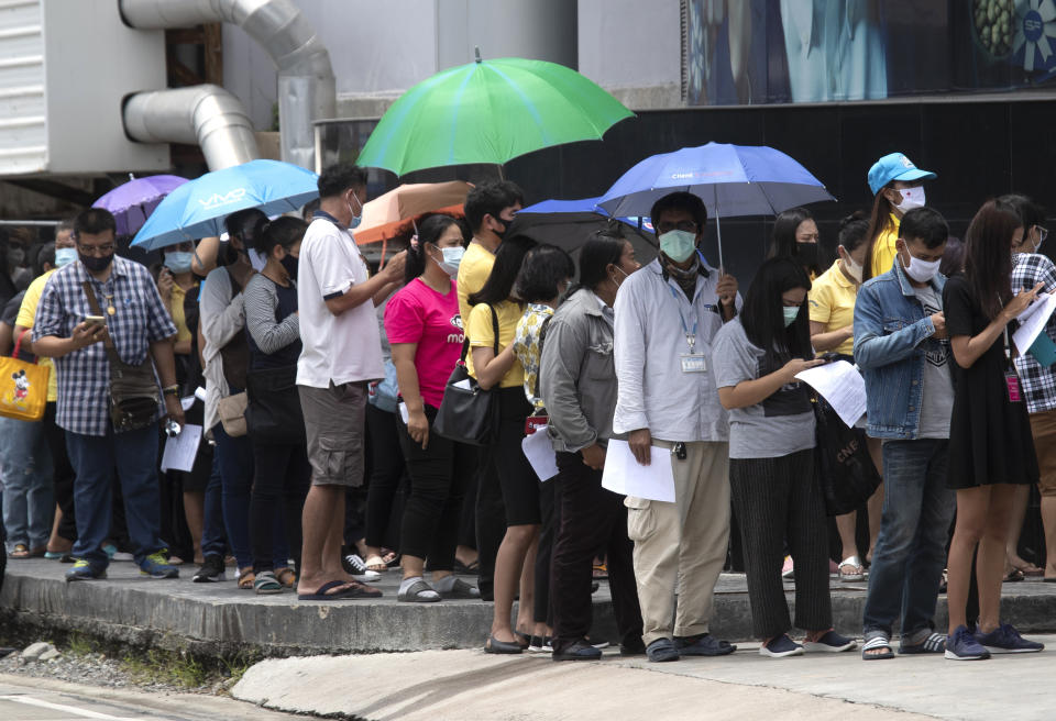 People line up for the coronavirus test in Rayong province, Thailand, Tuesday, July 14, 2020. Authorities set up testing for anyone concerned they might have come into contact with an Egyptian soldier who visited a shopping mall in Rayong last week and then tested positive for COVID-19. In Thailand, where there has been no reports of locally transmitted cases for seven weeks, health authorities were rushing to trace the contacts of two recent foreign arrivals in the country who were infected with the coronavirus and may have violated quarantine rules.(AP Photo/Sakchai Lalit)