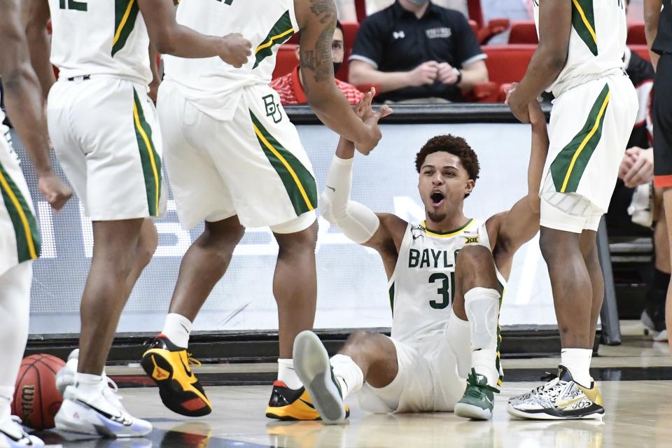 Baylor's MaCio Teague (31) is helped up by his teammates after drawing a foul against Texas Tech during the second half of an NCAA college basketball game in Lubbock, Texas, Saturday, Jan. 16, 2021. (AP Photo/Justin Rex)