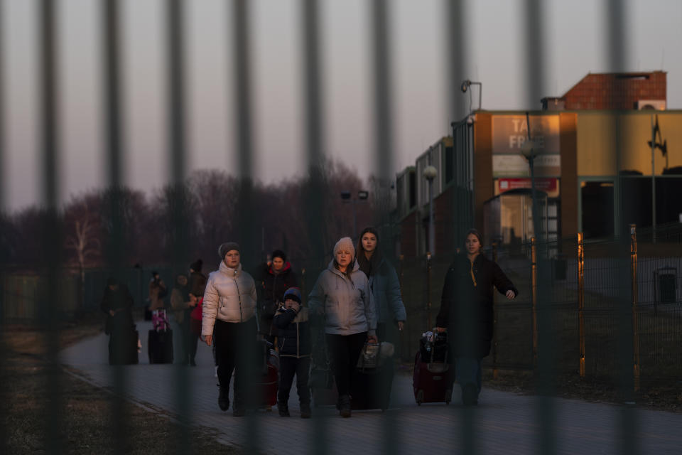 A group of people fleeing Ukraine arrive at the border crossing in Medyka, Poland, on Monday, March 14, 2022. Russia's military forces kept up their punishing campaign to capture Ukraine's capital with fighting and artillery fire in Kyiv's suburbs Monday after an airstrike on a military base near the Polish border brought the war dangerously close to NATO's doorstep. (AP Photo/Petros Giannakouris)