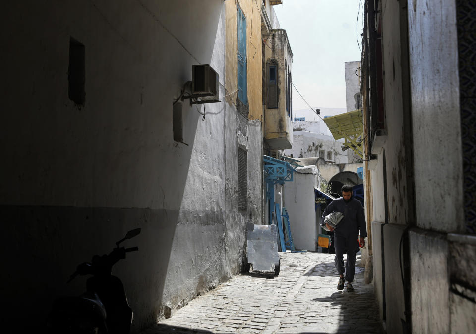 A man walks in an old alley, in the old city of Tunis, Tunisia, Thursday, March 28, 2019. Tunisia is cleaning up its boulevards and securing its borders for an Arab League summit that this country hopes raises its regional profile and economic prospects. Government ministers from the 22 Arab League states are holding preparatory meetings in Tunis all week for Sunday's summit. (AP Photo/Hussein Malla)