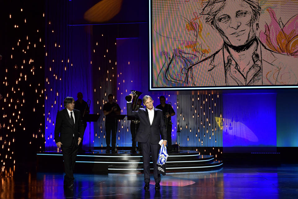 US actor and film director Viggo Mortensen, right, salutes after receiving the Donostia Award by Agustin Diaz Yanes for his contribution to the cinema during the 68th San Sebastian Film Festival, in San Sebastian, northern Spain, Thursday, Sept. 24, 2020. (AP Photo/Alvaro Barrientos)