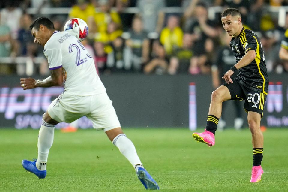Orlando defender Antonio Carlos dodges a kick from Crew midfielder Alex Matan on May 13.