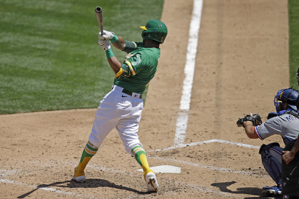 Oakland Athletics' Khris Davis swings for a two run single off Texas Rangers' Mike Minor in the fourth inning of a baseball game Thursday, Aug. 6, 2020, in Oakland, Calif. (AP Photo/Ben Margot)