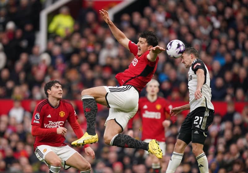 Manchester United's Harry Maguire and Fulham's Timothy Castagne battle for the ball during the English Premier League soccer match between Manchester United and Fulham at Old Trafford. Mike Egerton/PA Wire/dpa