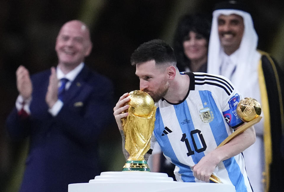 Argentina's Lionel Messi kisses the World Cup trophy after receiving the Golden Ball award for best player of the tournament during the awards ceremony after Argentina defeated France in the World Cup final soccer match at the Lusail Stadium in Lusail, Qatar, Sunday, Dec. 18, 2022. (AP Photo/Natacha Pisarenko)