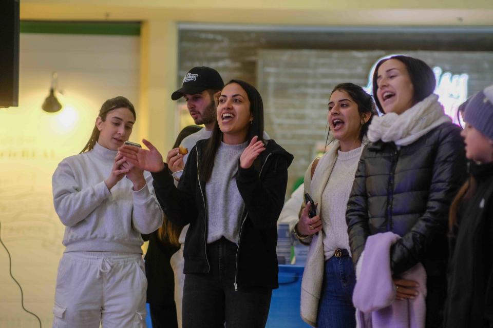 Members of the crowd join in singing during the celebration of the lighting of the menorah Thursday at the Westgate Mall In Amarillo.