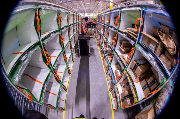 Employees sort parcels from online retailer Amazon at a distribution centre. (Photo: Getty Images)