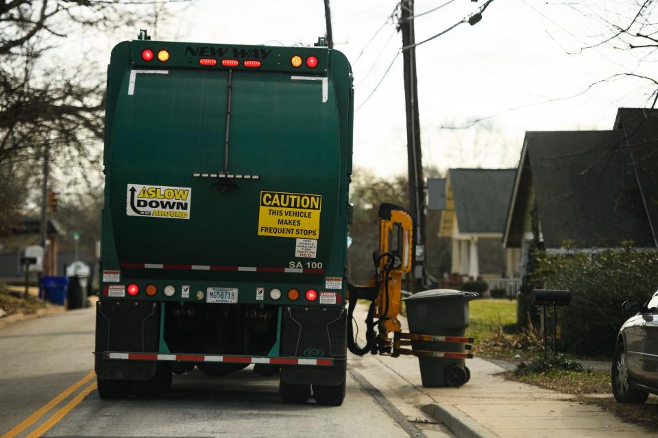 A garbage truck collects trash from a residence Wednesday, Jan. 27, 2021.