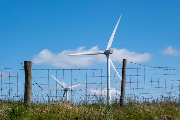 Wind turbines behind a wire fence on Ovenden Moor in West Yorkshire.