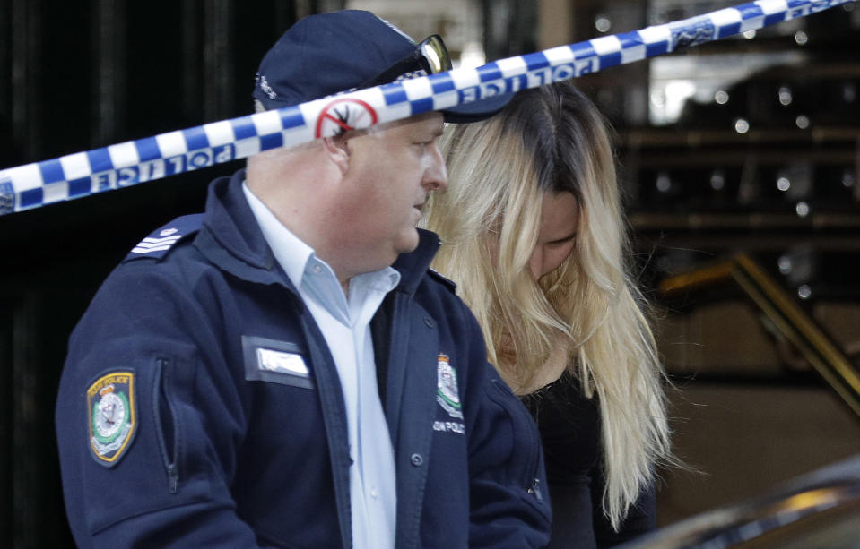 A woman is led out of a building by police after a man, wielding a long knife, attempted to stab several people in Sydney, Australia, Tuesday, Aug. 13, 2019. Police and witnesses say the knife-wielding man yelling "Allahu akbar," or "God is great," attempted to stab several people before being arrested, with one person taken to a hospital. (AP Photo/Rick Rycroft)