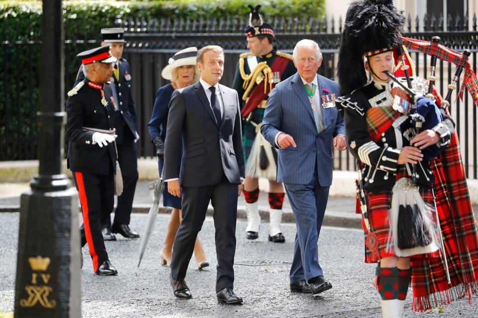 Britain's Camilla, Duchess of Cornwall (3rd L), Britain's Prince Charles, Prince of Wales (2nd R) and French President Emmanuel Macron (4th L) follow a piper as they arrive to lay wreaths at the statue of former French president Charles de Gaulle at Carlton Gardens in central London on June 18, 2020 during a visit to mark the anniversary of former de Gaulle's appeal to French people to resist the Nazi occupation. - Macron visited London on June 18 to commemorate the 80th anniversary of former French president Charles de Gaulle's appeal to French people to resist the Nazi occupation during World War II. (Photo by Tolga AKMEN / POOL / AFP) (Photo by TOLGA AKMEN/POOL/AFP via Getty Images)