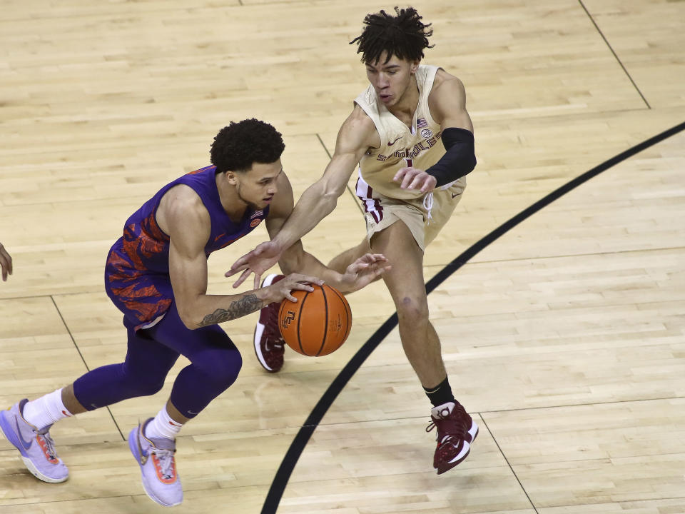 At right, Florida State guard Jalen Warley goes for a steal on Clemson guard Chase Hunter in the first half of an NCAA college basketball game in Tallahassee, Fla., Saturday, Jan. 28, 2023. (AP Photo/Phil Sears)