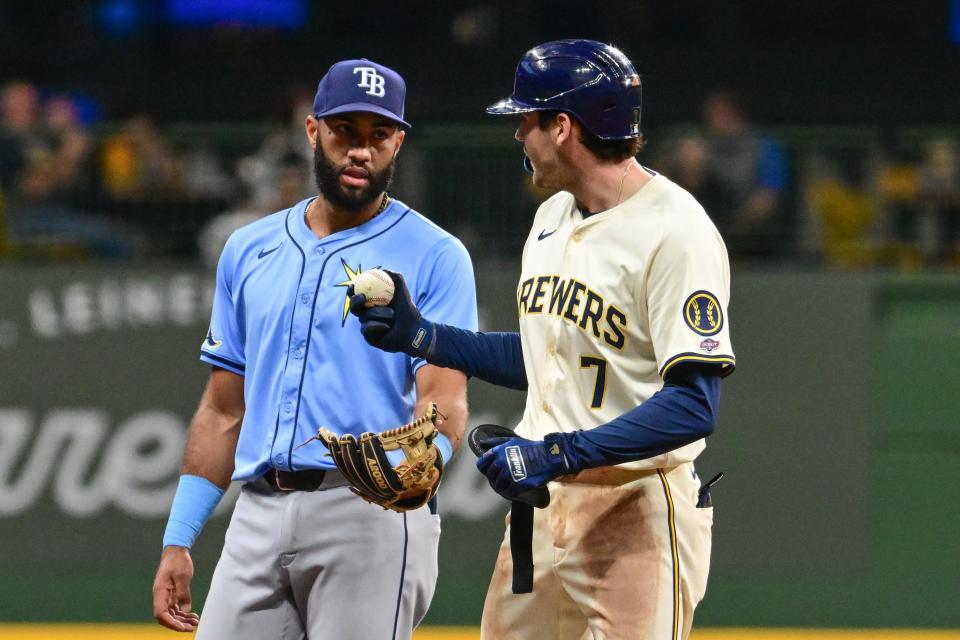 Brewers designated hitter Tyler Black gets the baseball from Rays second baseman Amed Rosario after getting his first major league hit in the third inning Tuesday night at American Family Field.