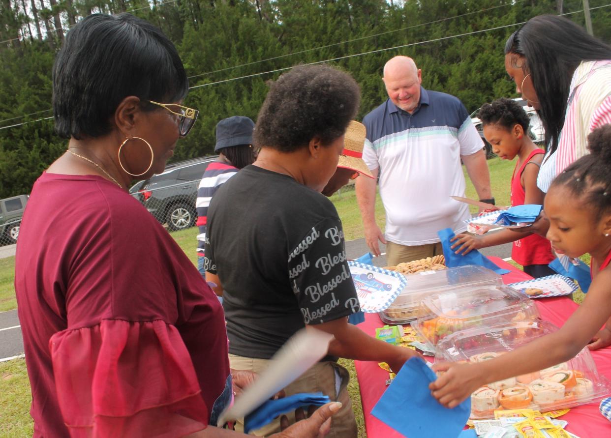 City Administrator Dwayne Flowers (at end of table) places food on a table for Wadley citizens attending the event.