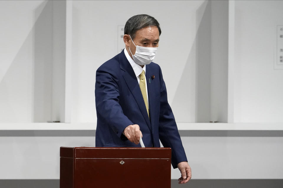 Japanese Chief Cabinet Secretary Yoshihide Suga casts his ballot at the Liberal Democratic Party's (LDP) leadership election Monday, Sept. 14, 2020, in Tokyo. The ruling LDP chooses its new leader in an internal vote to pick a successor to Prime Minister Shinzo Abe, who announced his intention to resign last month due to illness. (AP Photo/Eugene Hoshiko, Pool)