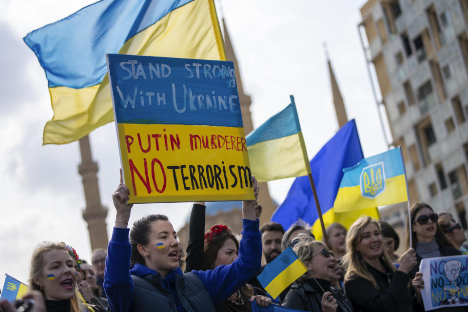 Ukrainians who live in Lebanon hold placards and chant slogans during a rally to mark the one-year anniversary of the Russian invasion of Ukraine at Martyrs' Square in downtown Beirut, Lebanon, Friday, Feb. 24, 2023. (AP Photo/Hassan Ammar)