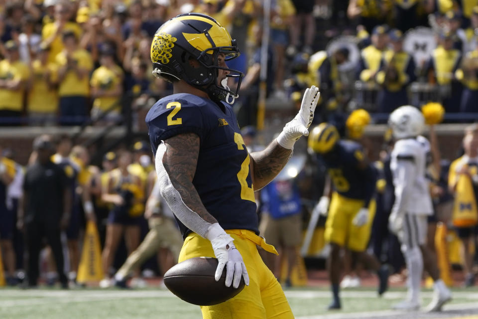 Michigan running back Blake Corum (2) celebrates an 11-yard touchdown against Connecticut by holding up five fingers in the second half of an NCAA college football game in Ann Arbor, Mich., Saturday, Sept. 17, 2022. Corum ran for five touchdowns in the game. (AP Photo/Paul Sancya)