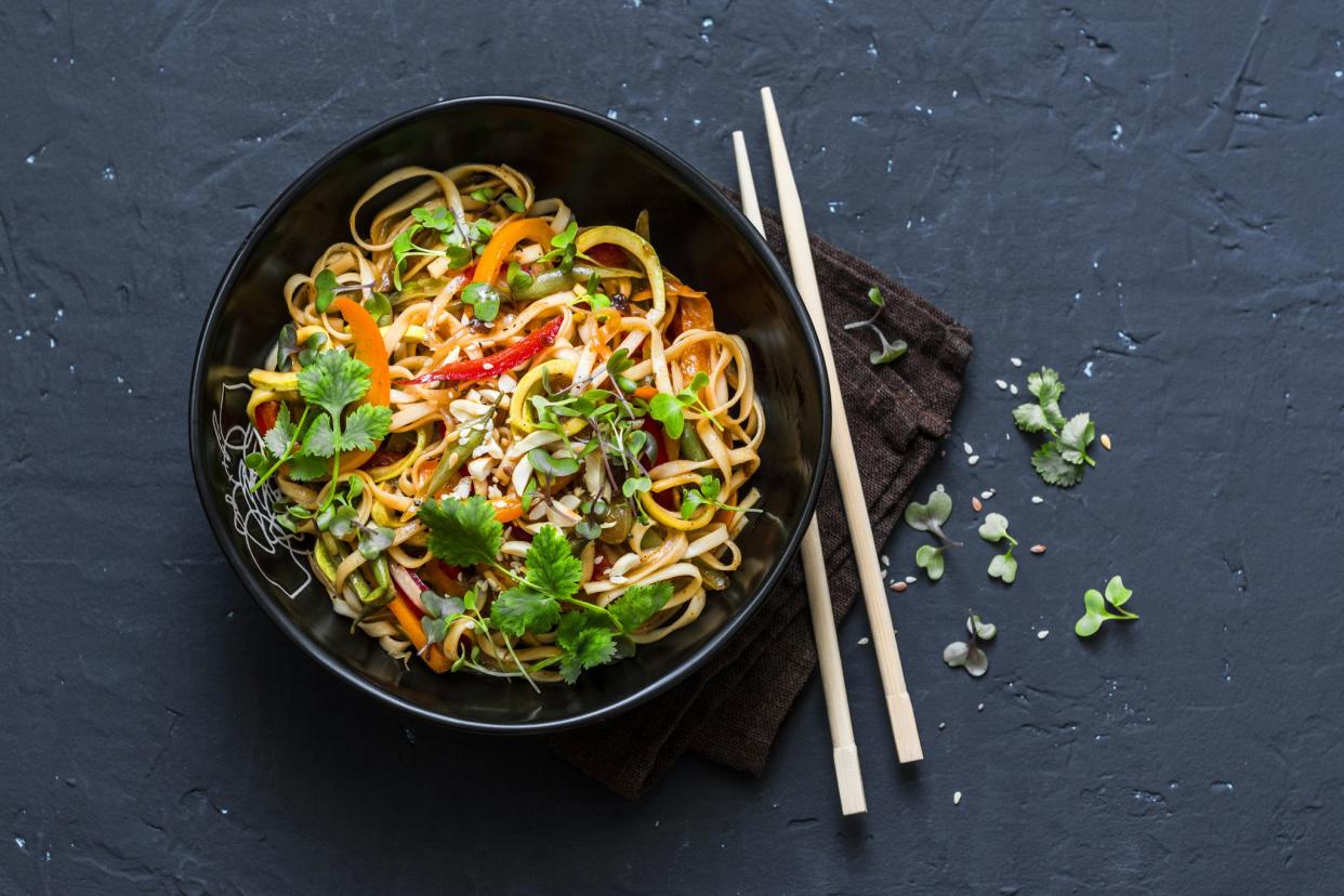 vegetarian pad thai on dark background, view from above, with chopsticks