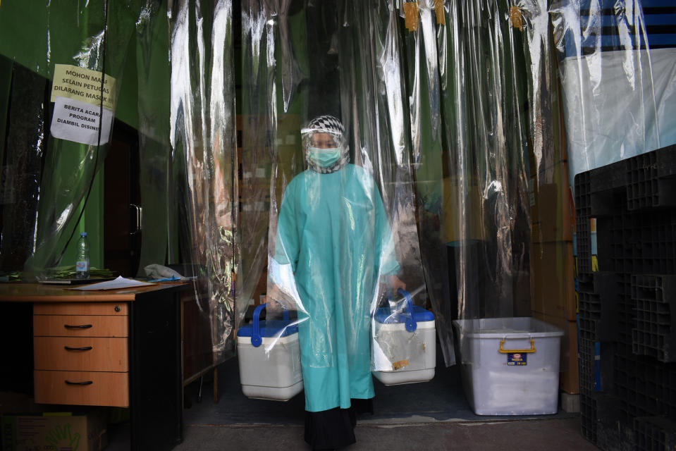 A health worker delivers containers of Covid-19 vaccines produced by China's Sinovac from a cold room in Bandung on Jan. 13 as the sprawling archipelago of nearly 270 million kicks off a mass inoculation drive in a bid to control soaring case rates<span class="copyright">Timur Matahari—AFP/Getty Images</span>