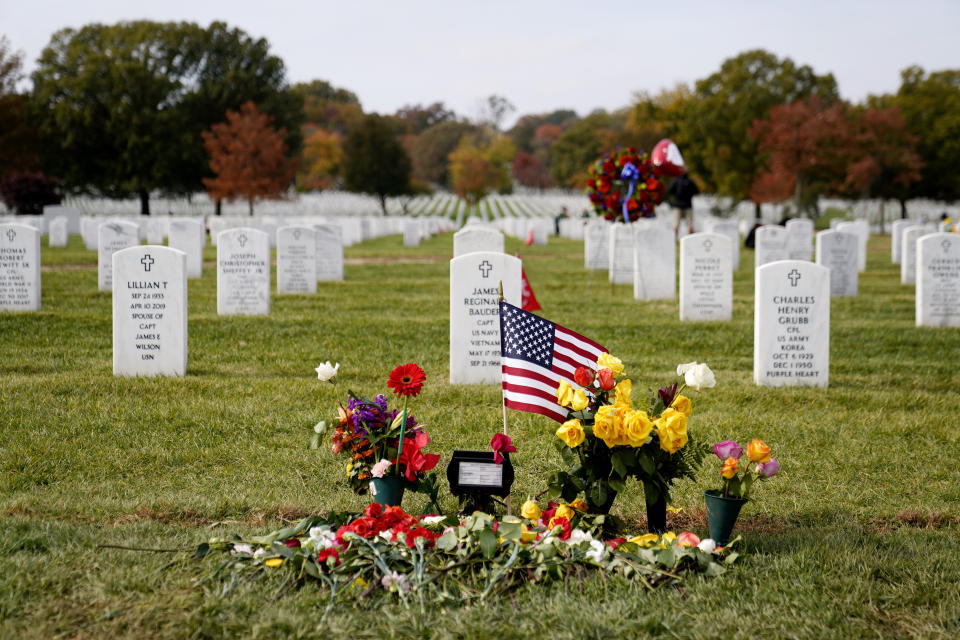 FILE - Flowers rest at the burial plot of former Secretary of State Colin Powell in Section 60 at Arlington National Cemetery, Nov. 11, 2021, in Arlington, Va. A trial underway in federal court will decide whether the U.S. government must pay up to $21 million to compensate a Virginia county for a parcel of land taken to expand Arlington National Cemetery. The cemetery expansion project has already begun work and is expected to extend the cemetery’s life by nearly 20 years, until 2060. (AP Photo/Patrick Semansky, File)