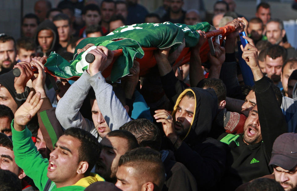 Palestinians carry the body of Hamza Abu el-Heija, who was killed in a raid by Israeli troops, during his funeral procession, in the West Bank refugee camp of Jenin, Saturday, March 22, 2014. Israeli troops killed at least four Palestinians in an early morning raid that was followed by a clash with angry protesters in a West Bank town on Saturday, the Israeli military and Palestinian security officials said, in the deadliest incident in months. The Israeli military said the raid aimed to arrest Hamza Abu el-Heija, a 22-year-old Hamas operative wanted for involvement in shooting and bombing attacks against Israelis. (AP Photo/Mohammed Ballas)