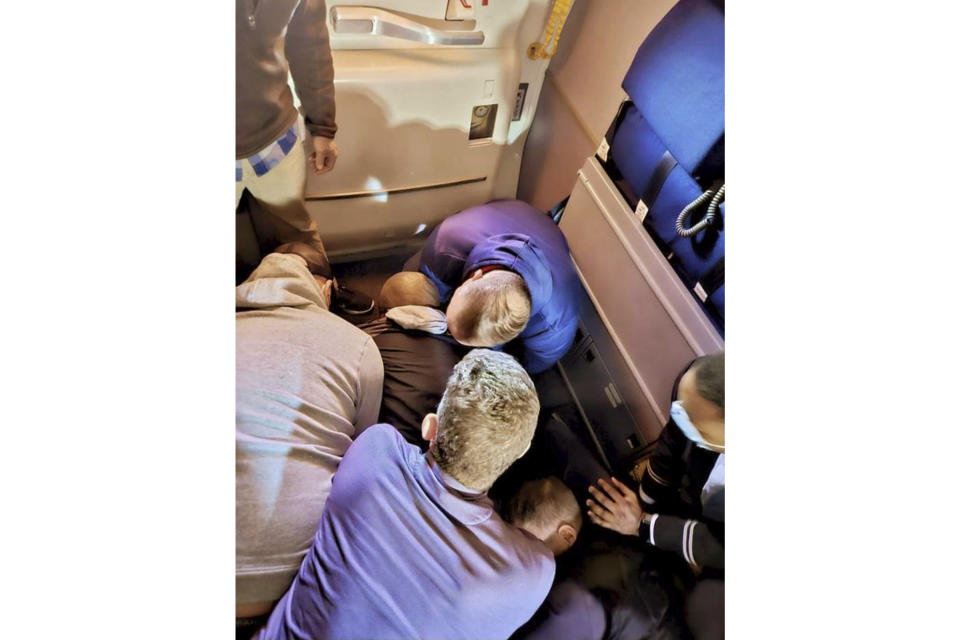 FILE — This image provided by Simik Ghookasian shows passengers and crew members restraining a man who according to federal authorities tried to stab a flight attendant on a flight from Los Angeles to Boston on March 5, 2023. Francisco Torres, the Massachusetts man accused of attacking the flight attendant and attempting to open the plane's emergency door on a cross-country flight, has directed attention to passengers with mental health challenges. (Simik Ghookasian via AP, File)
