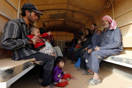 Syrian refugees board a Jordanian army vehicle after they crossed into Jordanian territory with their families, in Al Ruqban border area, near the northeastern Jordanian border with Syria, and Iraq, near the town of Ruwaished, 240 km (149 miles) east of Amman September 10, 2015. Picture taken September 10, 2015.REUTERS/Muhammad Hamed