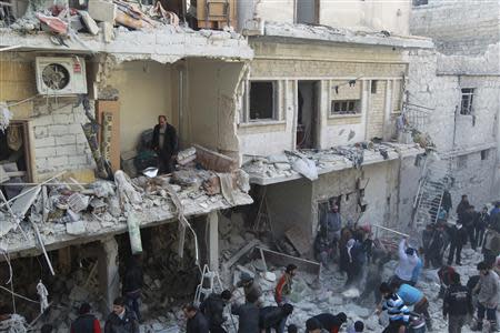 Residents search for survivors after what activists said were air strikes by forces loyal to Syria's President Bashar al-Assad in the Maysar neighbourhood of Aleppo December 28, 2013. REUTERS/Jalal Alhalabi