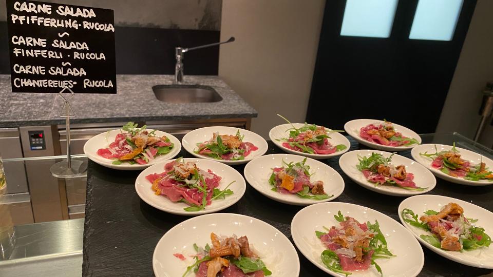 Meat salad with chanterelle mushrooms buffet, with sign translating into Italian, German and French