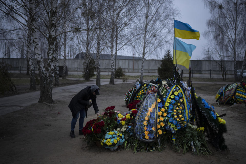Anna Korostenska visits the grave of her late fiancee, Oleksii Zavadskyi, in Bucha, Ukraine, Monday, Jan. 23, 2023. As the conflict that killed her loved one still rages on, Anna wrestles with a question that all of war-torn Ukraine must grapple with: After loss, what comes next? (AP Photo/Daniel Cole)