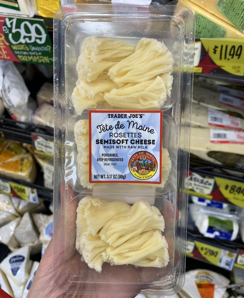 Hand holding clear pack of cheese rosettes at Trader Joe's