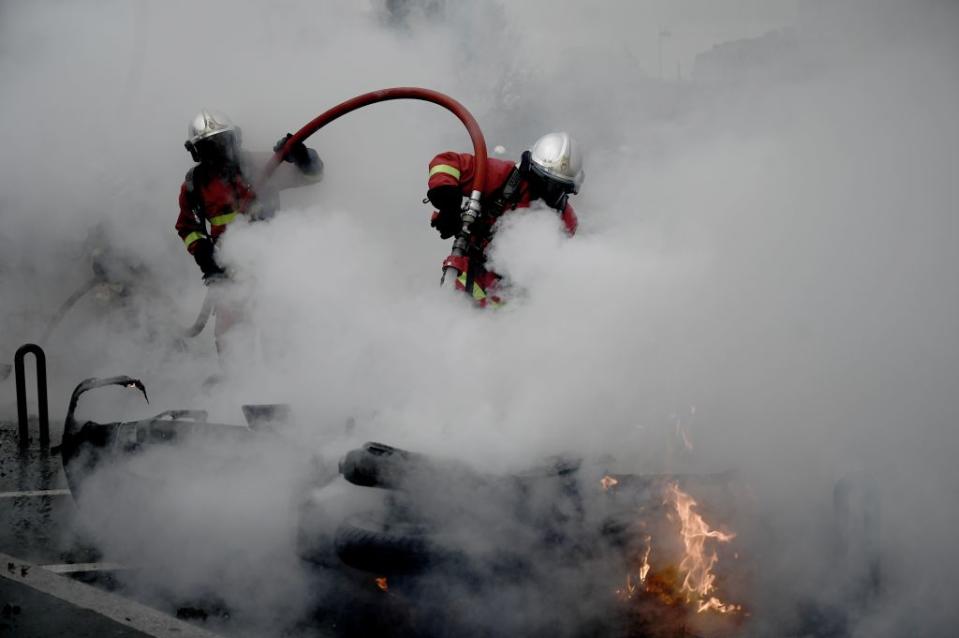 Émaillée par divers incidents, cette journée de manifestations à Paris a également vu les pompiers être pris à partie et empêchés par certains individus de faire leur travail en éteignant des incendies volontaires. La préfecture de police de Paris sur son compte Twitter a pour sa part dénoncé une "attitude scandaleuse des manifestants qui ont jeté des pavés sur les pompiers de Paris". ©PHILIPPE LOPEZ/AFP via Getty Images)