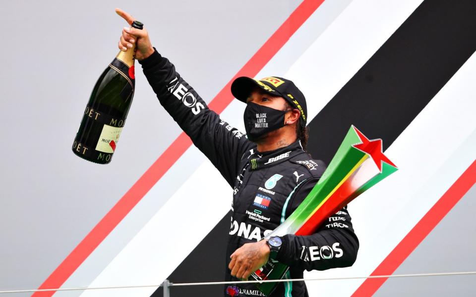 Race winner Lewis Hamilton of Great Britain and Mercedes GP celebrates his record breaking 92nd race win on the podium during the F1 Grand Prix of Portugal at Autodromo Internacional do Algarve on October 25, 2020 in Portimao, Portugal. - Bryn Lennon/Formula 1