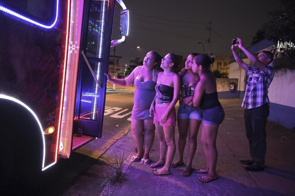 Women talk to bus driver Edilson, 45, also known as "Fumassa", inside an urban bus decorated with Christmas motives in Santo Andre