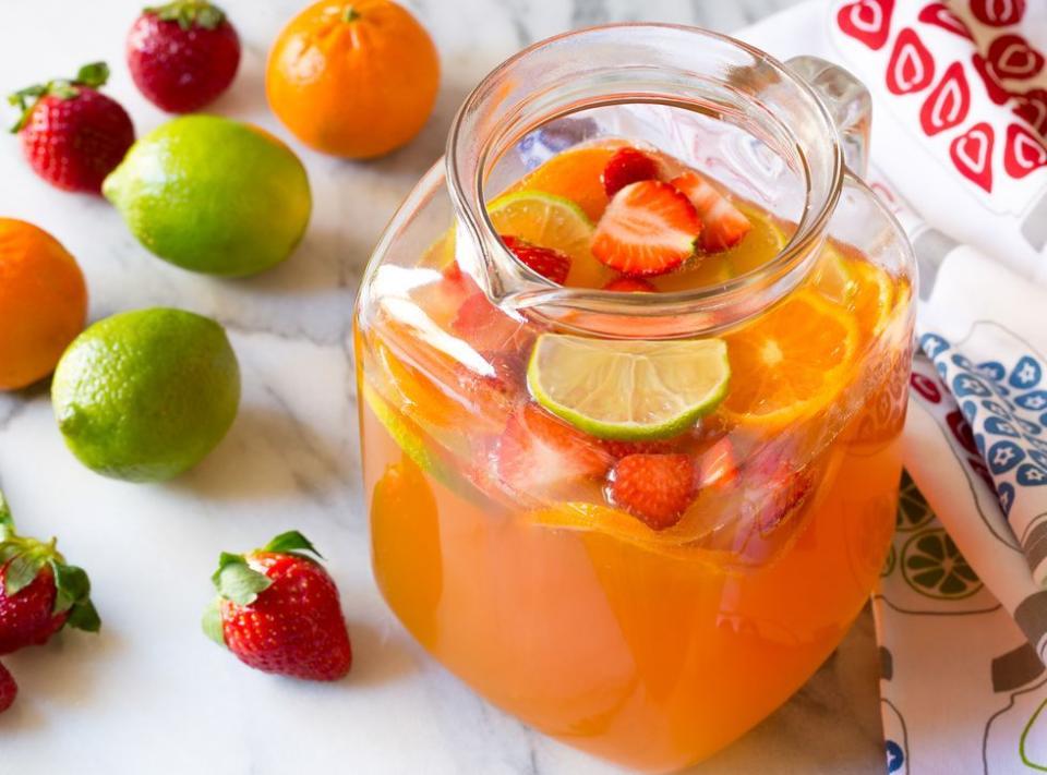 pitcher of sangria with strawberries, limes and oranges