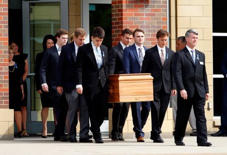 The casket of Otto Warmbier is carried to the hearse followed by his family and friends after his funeral service at Wyoming High School in Wyoming, Ohio. REUTERS/John Sommers II