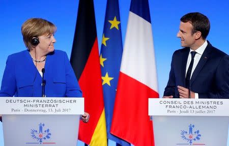 French President Emmanuel Macron and German Chancellor Angela Merkel attend a news conference following a Franco-German joint cabinet meeting at the Elysee Palace in Paris, France, July 13, 2017. REUTERS/Stephane Mahe