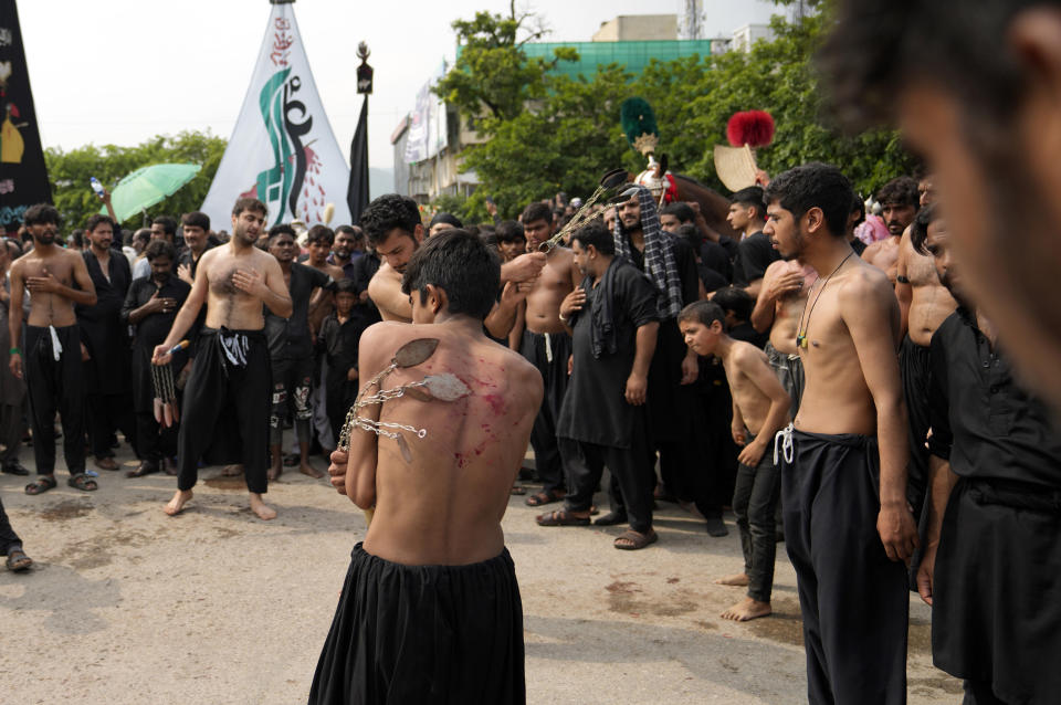 Shiite Muslims flagellate themselves with knifes on chains during a procession to mark Ashoura, in Islamabad, Pakistan, Friday, July 28, 2023. Ashoura is the Shiite Muslim commemoration marking the death of Hussein, the grandson of the Prophet Muhammad, at the Battle of Karbala in present-day Iraq in the 7th century. (AP Photo/Rahmat Gul)