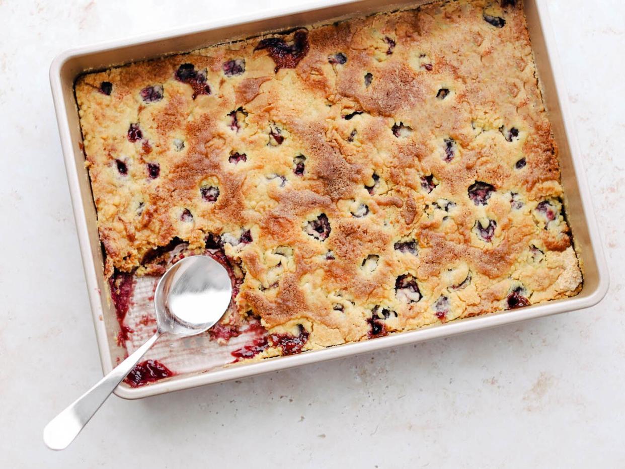 cherry dump cake in a pan with a scoop taken out