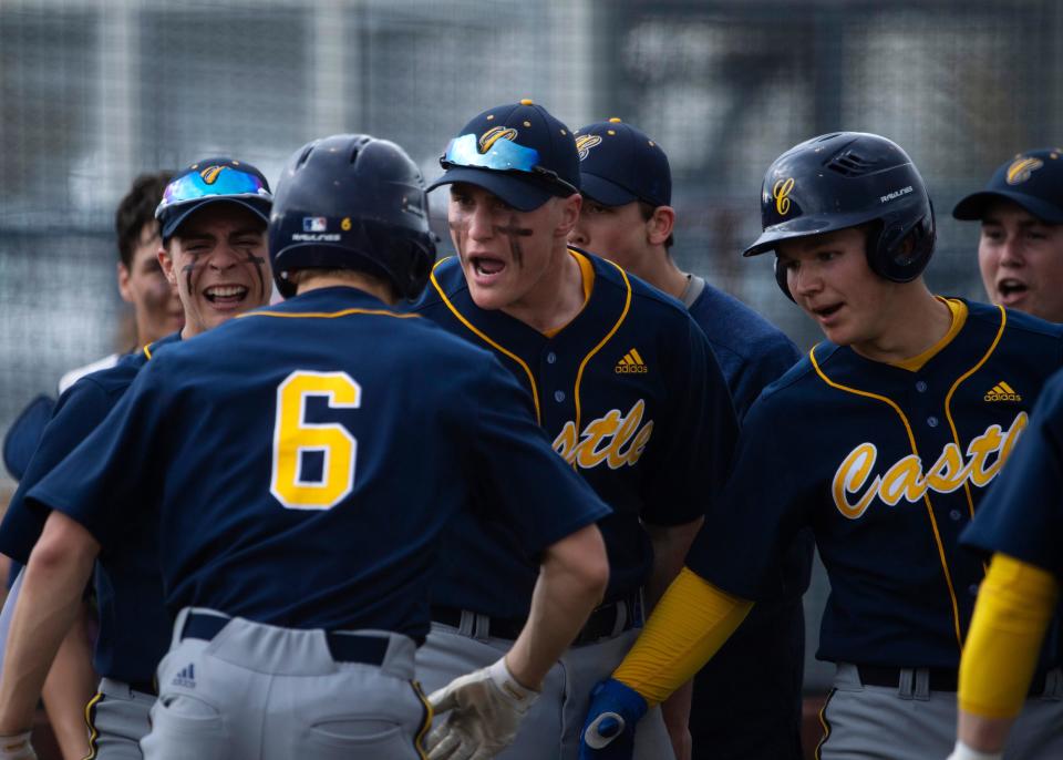 Castle's Caleb Niehaus (6) is mobbed by his team after hitting a homerun against North at Castle High School Tuesday evening, April 12, 2022.