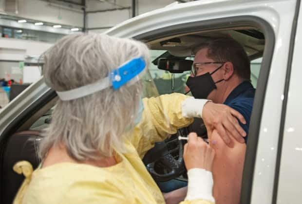 Saskatchewan Premier Scott Moe receives a dose of the Pfizer-BioNTech vaccine at a COVID-19 vaccination drive-thru clinic at Evraz Place in Regina on April 15. As of Friday, Saskatchewan ranked first among Canadian provinces in vaccine administration per capita.